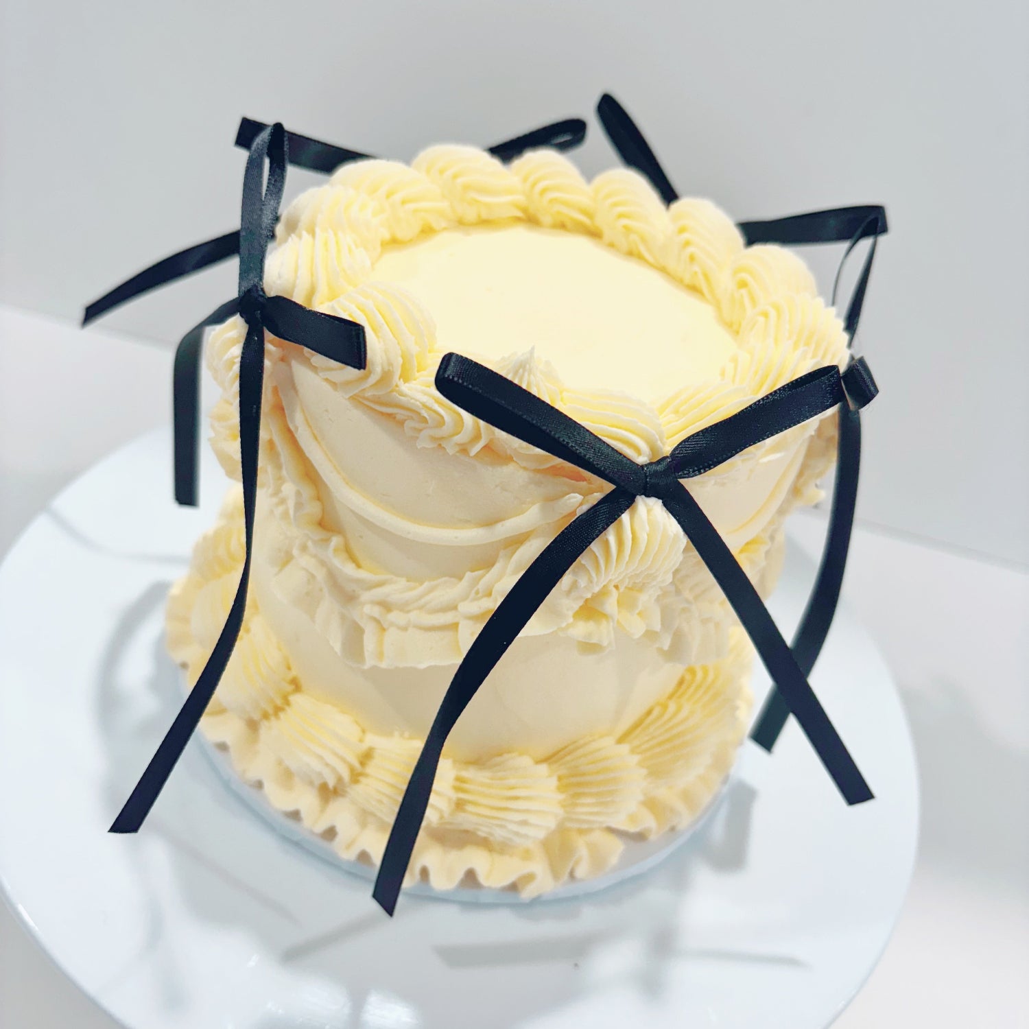 White 4 inch vintage cake with black bow decorations 
