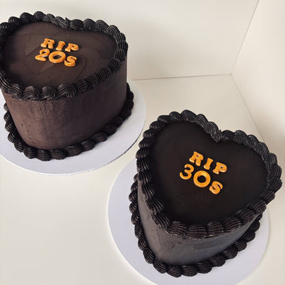 Two heart-shaped 8 inch chocolate cakes with black buttercream gold 'RIP 30s' fondant letters 