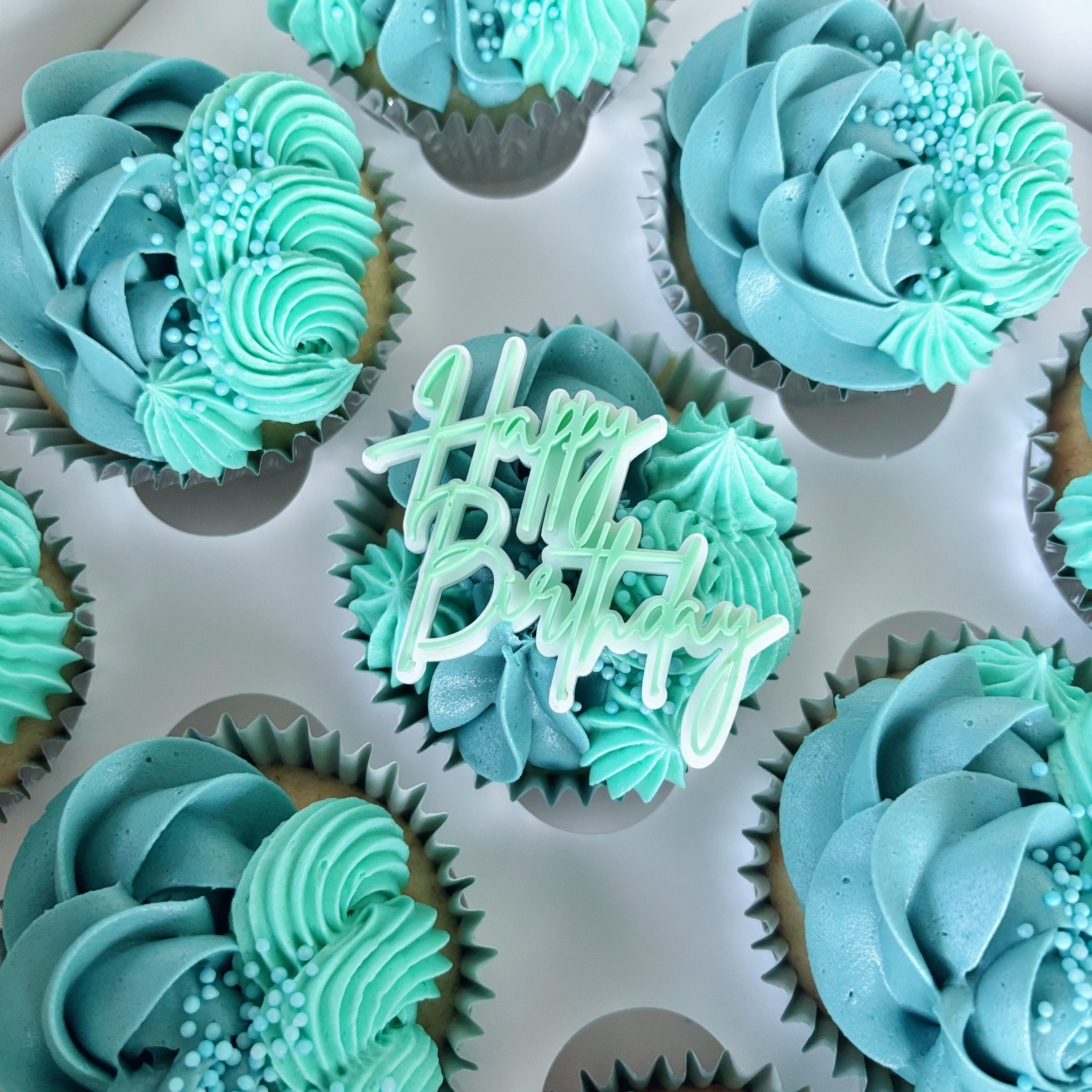 Turquoise buttercream cupcakes with 'Happy Birthday' topper 