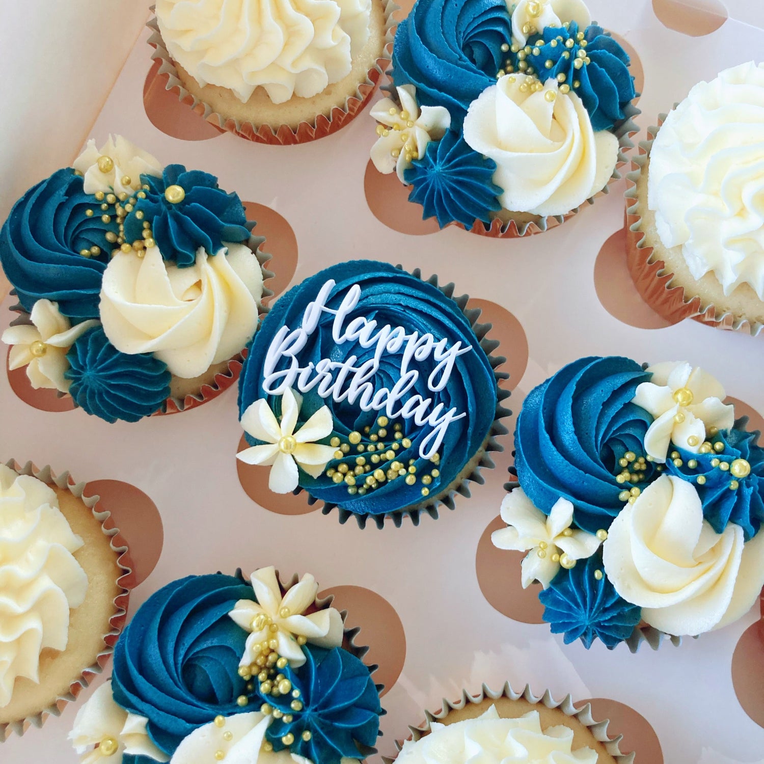 Decorative cupcakes with navy and white frosting with Happy Birthday topper