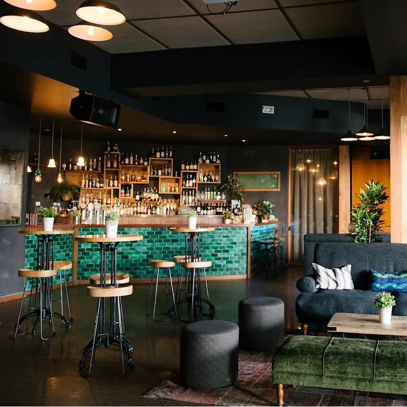 Modern bar Loft in West End with dark interior, green accents, and a cozy atmosphere for baking class