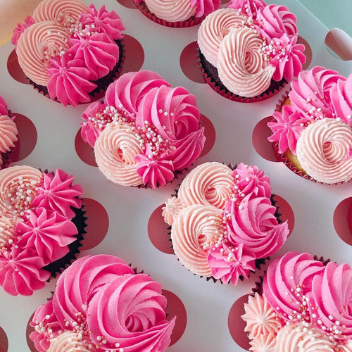 Pink cupcakes with pink and peach frosting.