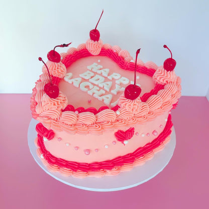 Pink 8 inch birthday cake with cherry decorations & buttercream piping